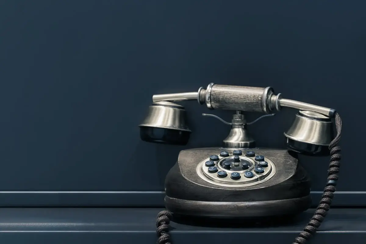 Nostalgisches Tastentelefon im Retro-Stil vor einer dunkelblauen Wand